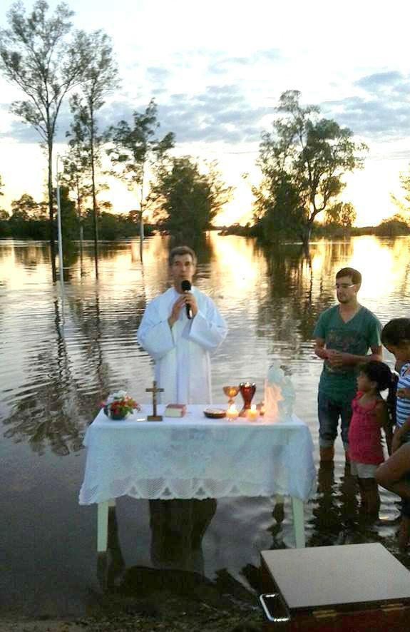 El sacerdote con los pies en aguas del Uruguay (foto: Facebook de Haroldo Luibici)