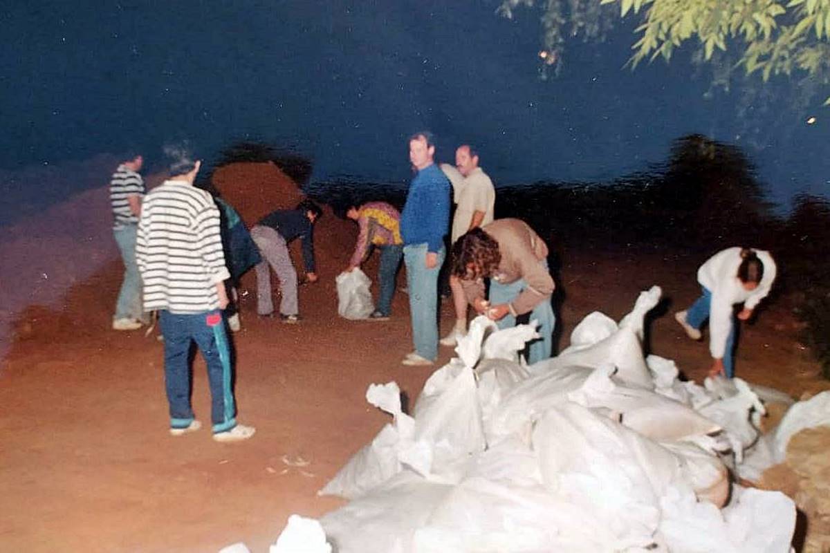 Los vecinos acomodando las bolsas con arena para frenar el avance del río (Crédito: José González)