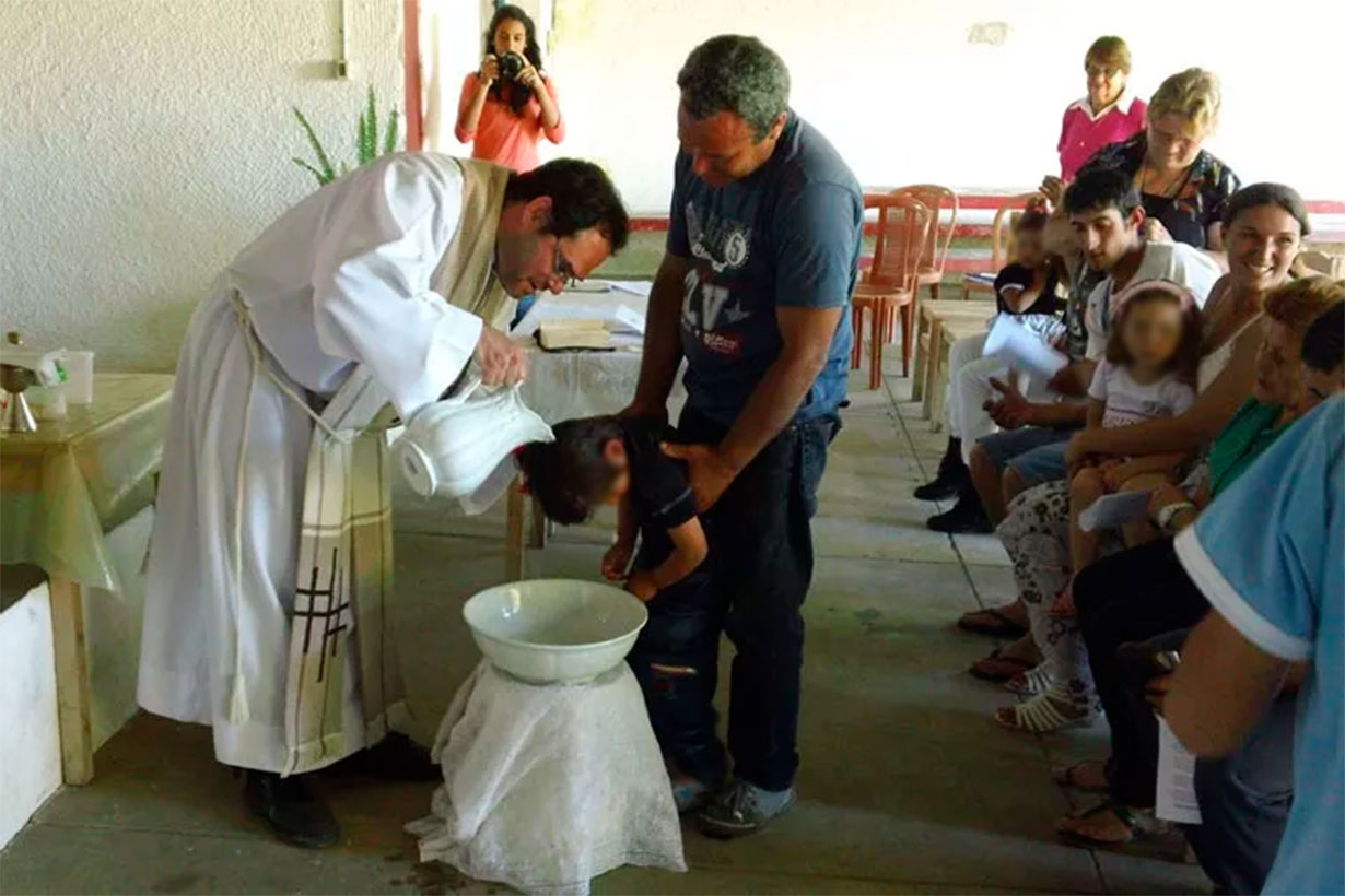 El sacerdote amenazado, celebrando un bautismo