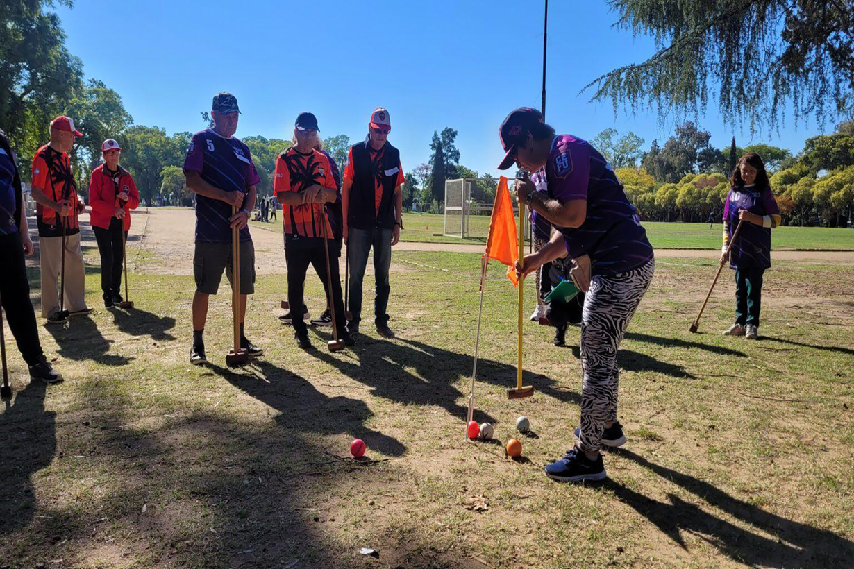 Adultos mayores disputando una partida de croquet