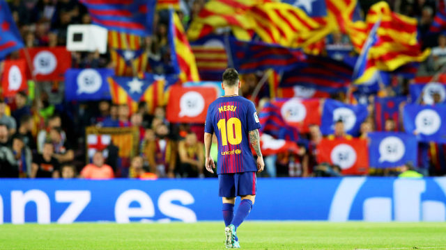 Messi en la cancha, con banderas catalanas atrás.